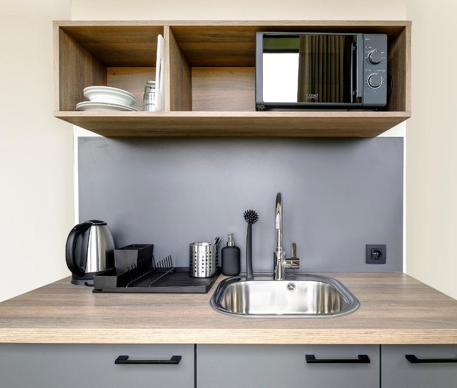 uma cozinha com um lavatório e um micro-ondas em Go Hotel City em Copenhaga