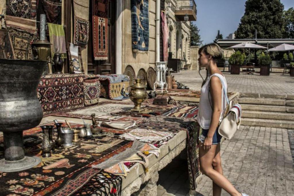 Una mujer caminando por una calle cerca de un edificio en Baku Tour Hotel & Hostel en Bakú
