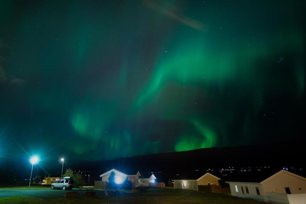 an image of the northern lights in the sky at Saeluhus Apartments & Houses in Akureyri