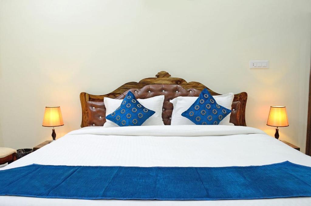 a bedroom with a large bed with blue and white pillows at Krishna Kunj in Udaipur