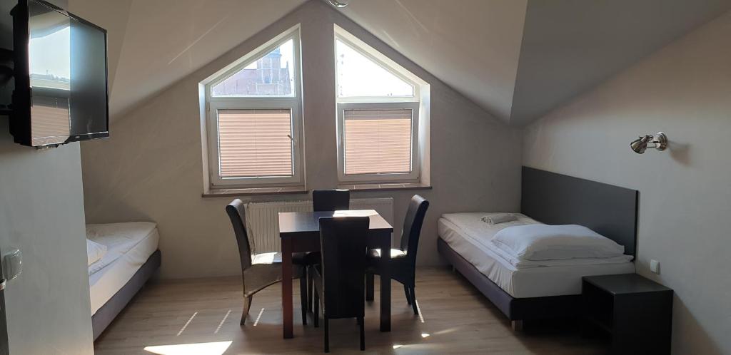 Habitación con mesa, cama y ventana en Résidence Tournet, en Cracovia
