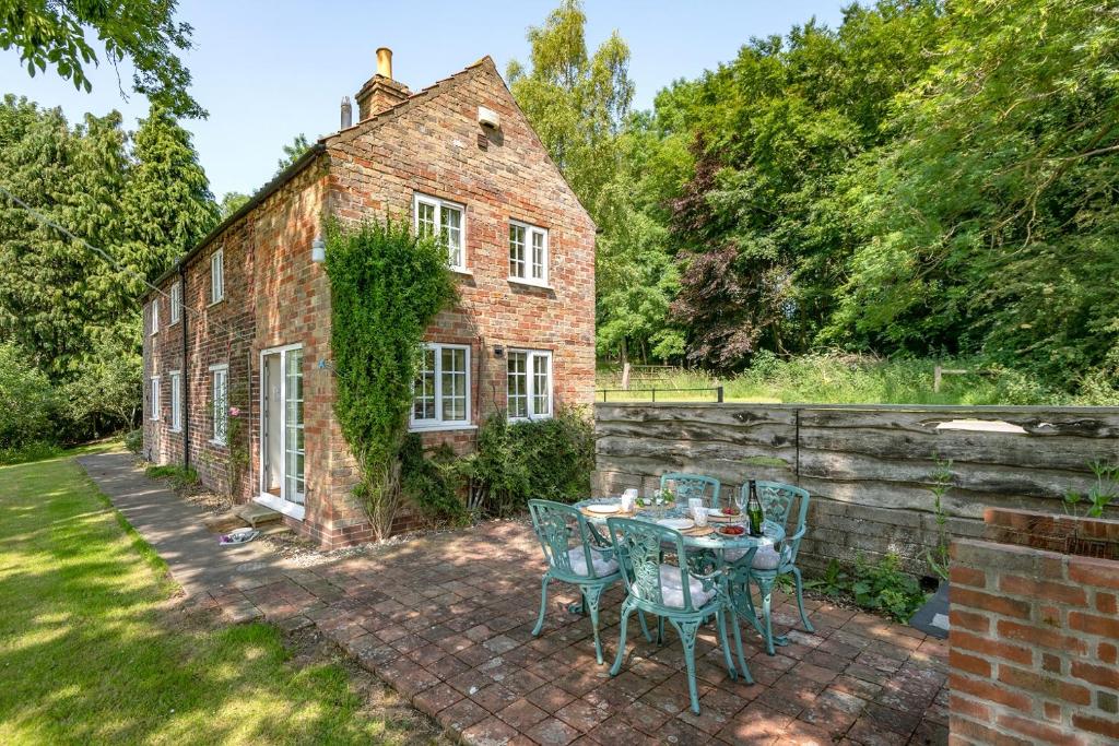 a table and chairs in front of a brick building at Marris Cottage in Grimsby
