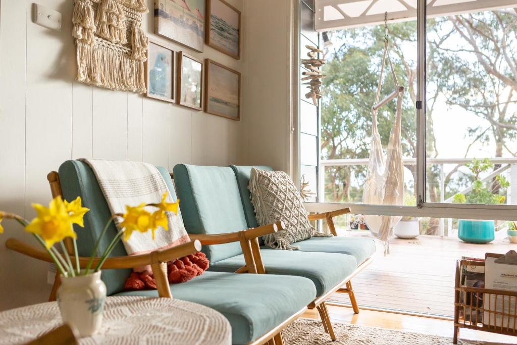 a living room with a couch and a table at Boho Cottage in White Beach