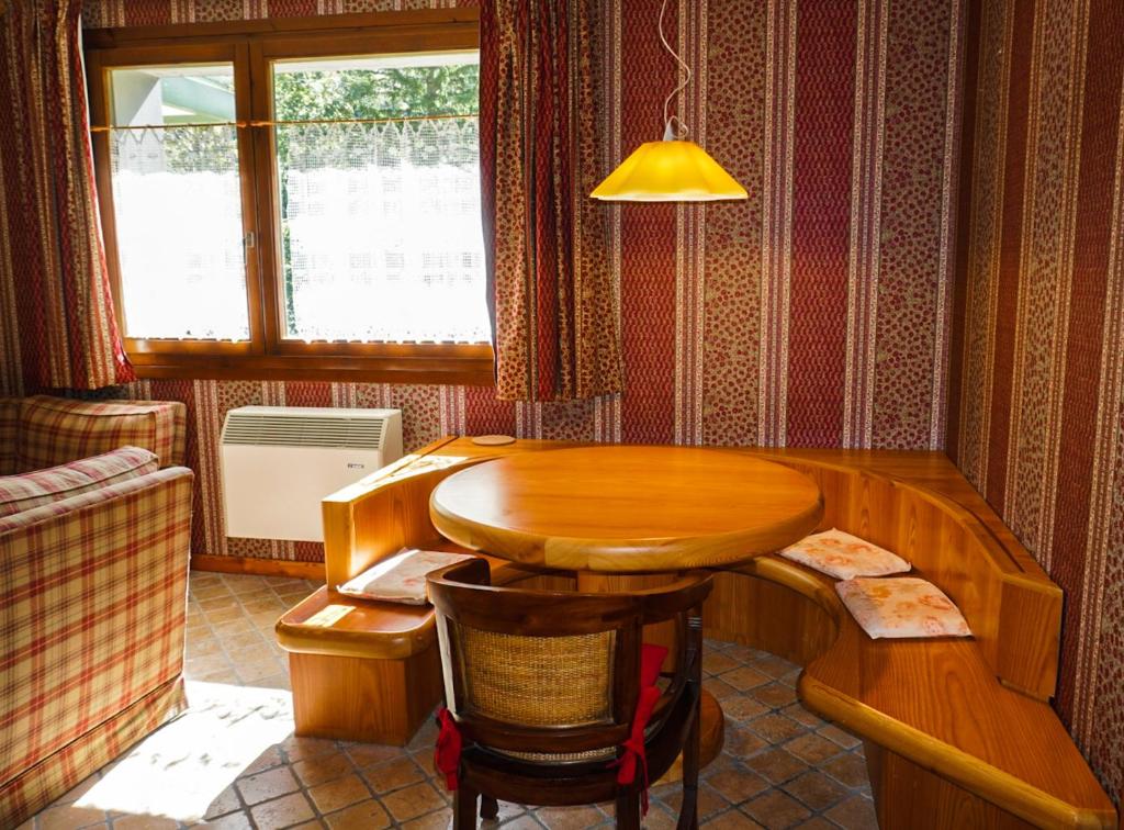 Faidello的住宿－Suite sulle piste，客房设有木桌和窗户。