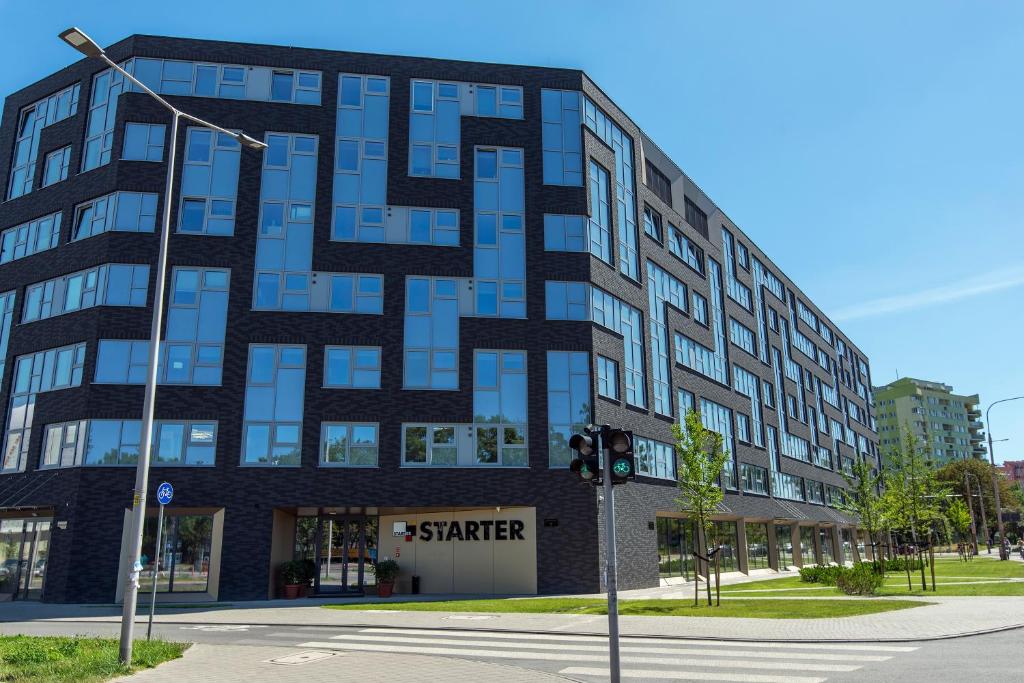 a large building with blue windows on a street at Starter III in Wrocław