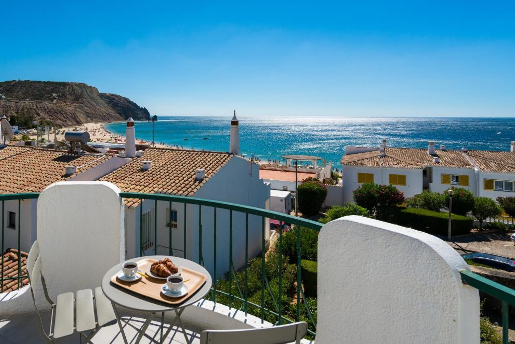 a balcony with a table and chairs and the ocean at Waterside Village - Sea View Apartment in Alagoas