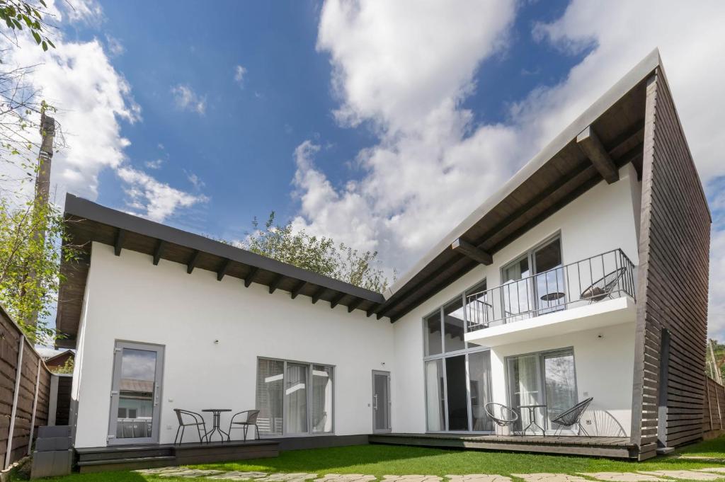 Cette maison moderne est dotée de murs et de fenêtres blancs. dans l'établissement Cottage RoKSa 2, à Slavsko