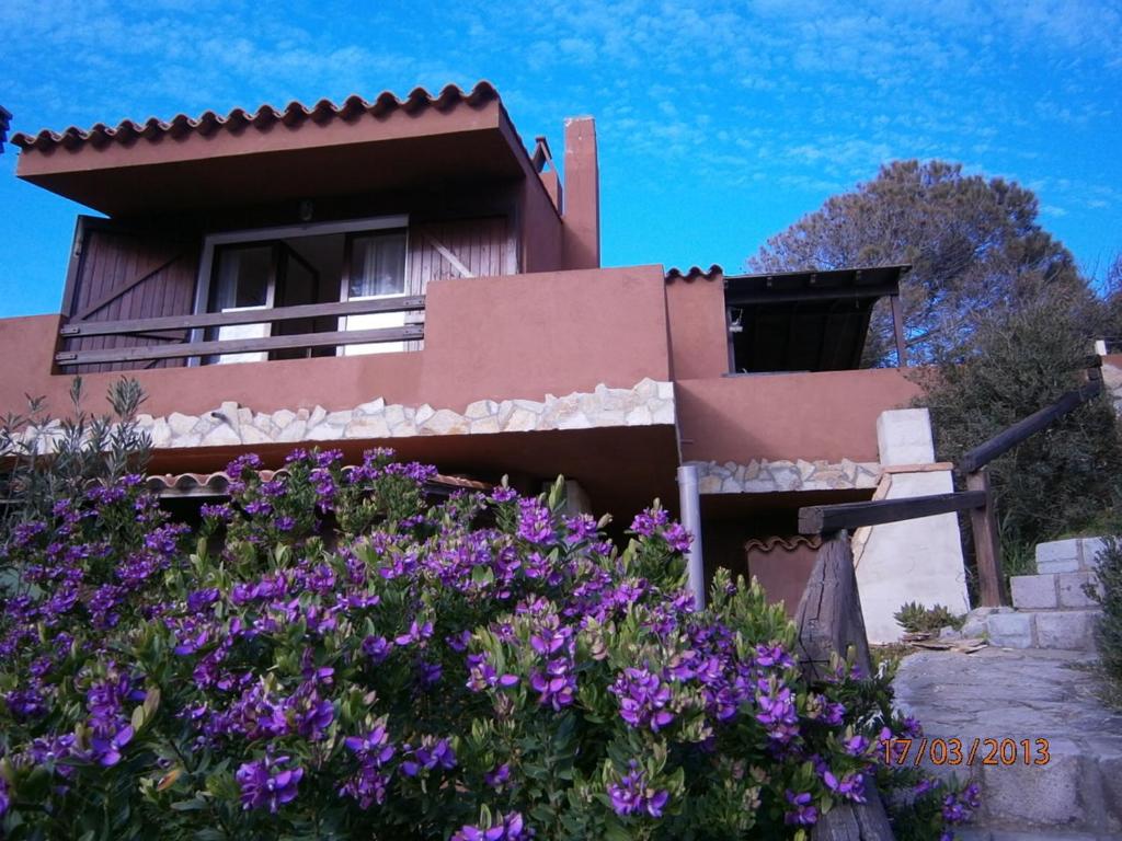 una casa con fiori viola di fronte di Casa Michela a Torre Dei Corsari