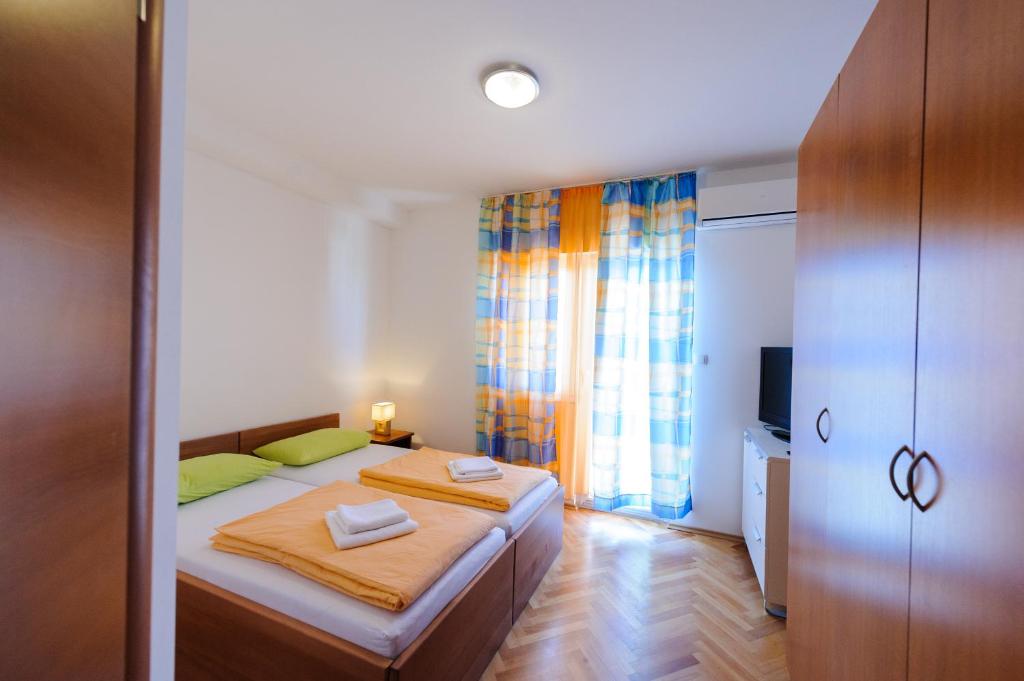 a bedroom with a bed with two pillows on it at Apartment and Rooms Iva in Split