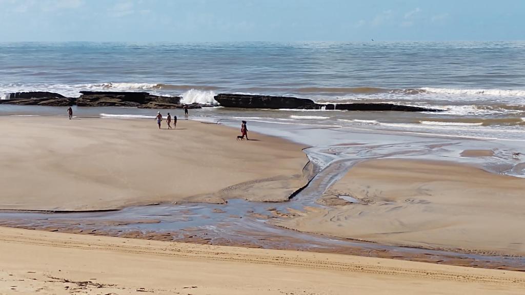 a group of people walking on the beach at Pousada Pargos in Itaúnas