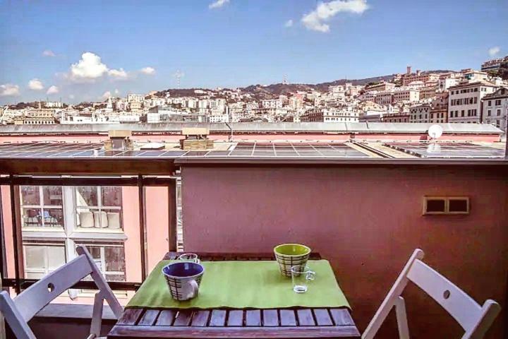 a table on a balcony with a view of a city at 616 Genova - Loft al Porto Antico in Genoa