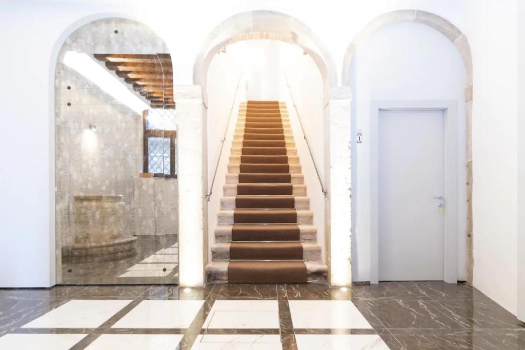 a staircase in a building with two arches and a stair case at Il Pozzo Magico in Venice