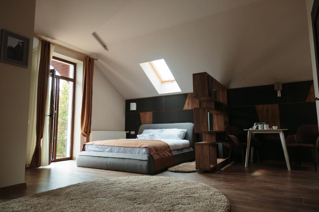 1 dormitorio con cama, mesa y ventana en Кайзервальд Forus - апартаменти в Карпатах en Karpaty