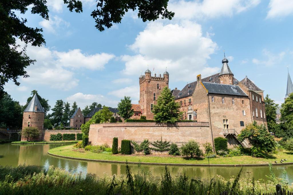 een oud kasteel met een rivier ervoor bij Kasteel Huis Bergh in 's-Heerenberg