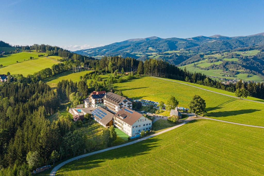 an aerial view of a house in a green field at Hotel Moselebauer in Bad Sankt Leonhard im Lavanttal
