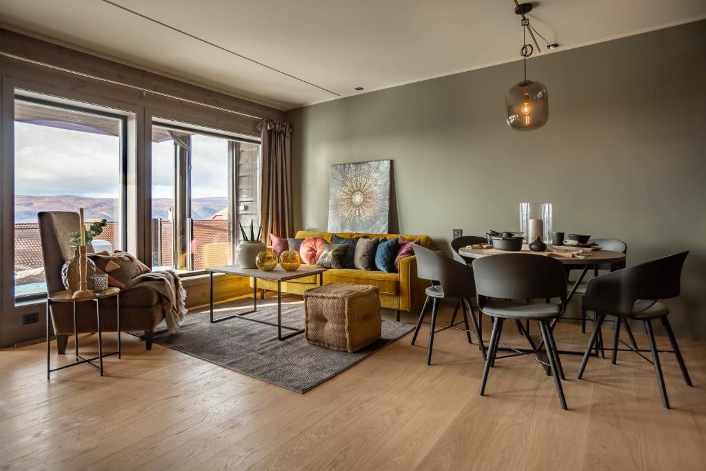 a living room with a yellow couch and a table at Riddertunet Leiligheter in Beitostøl