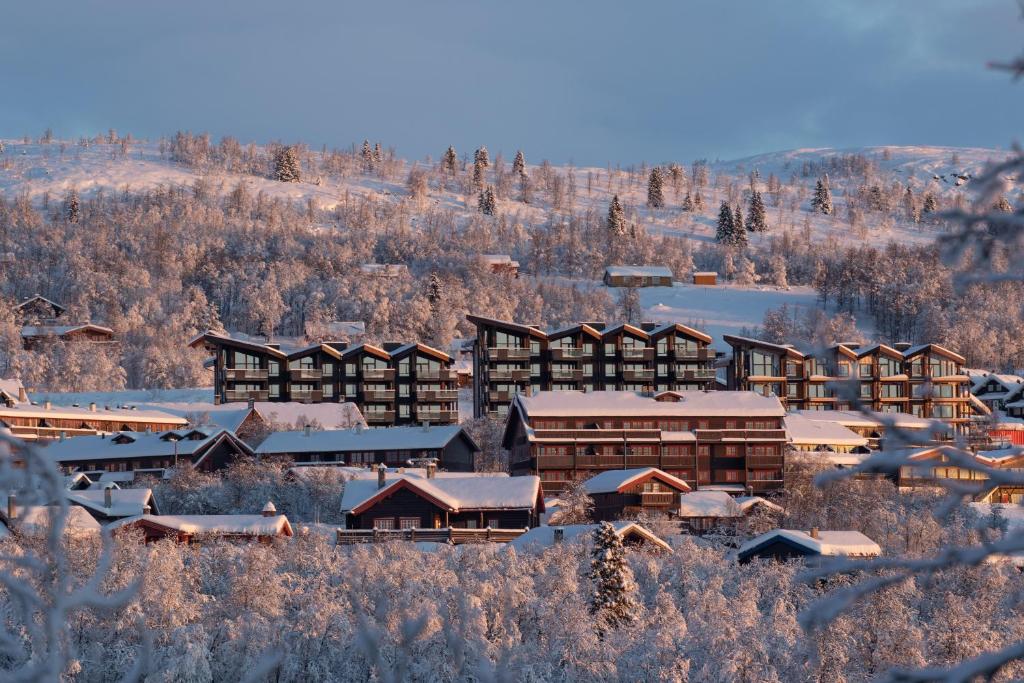 a ski lodge with snow on the roofs at Ridderleiligheter in Beitostøl