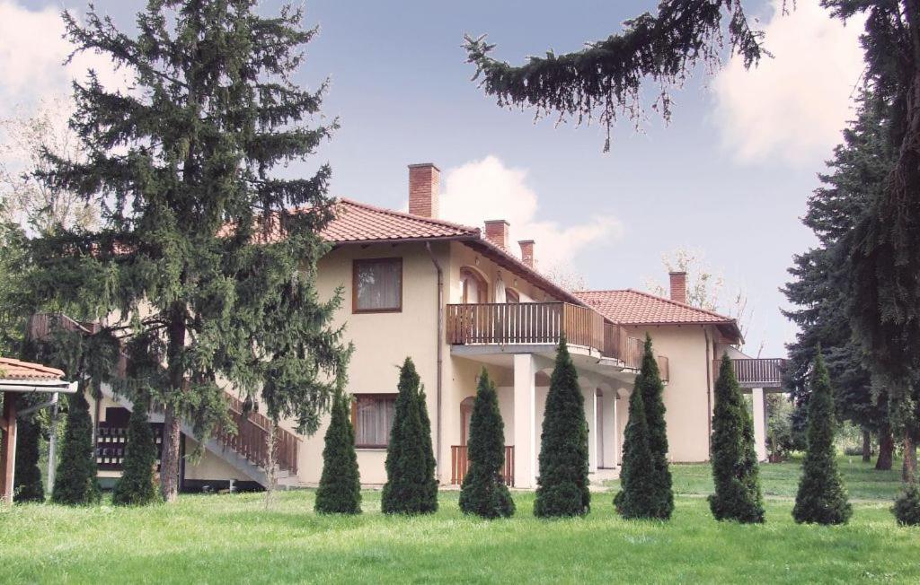 una casa grande con árboles delante de ella en Liget lakópark, en Fonyód