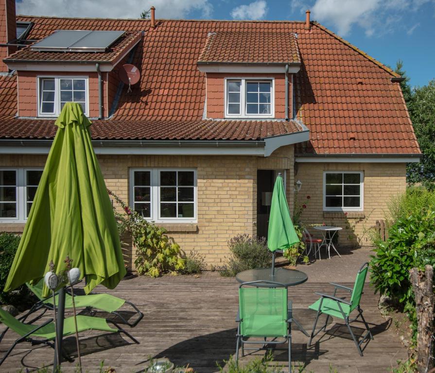 a house with a patio with chairs and umbrellas at Ferienwohnung Zimmert in Zimmert