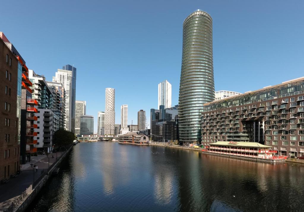 a view of a river in a city with tall buildings at StayInn Canary Wharf in London