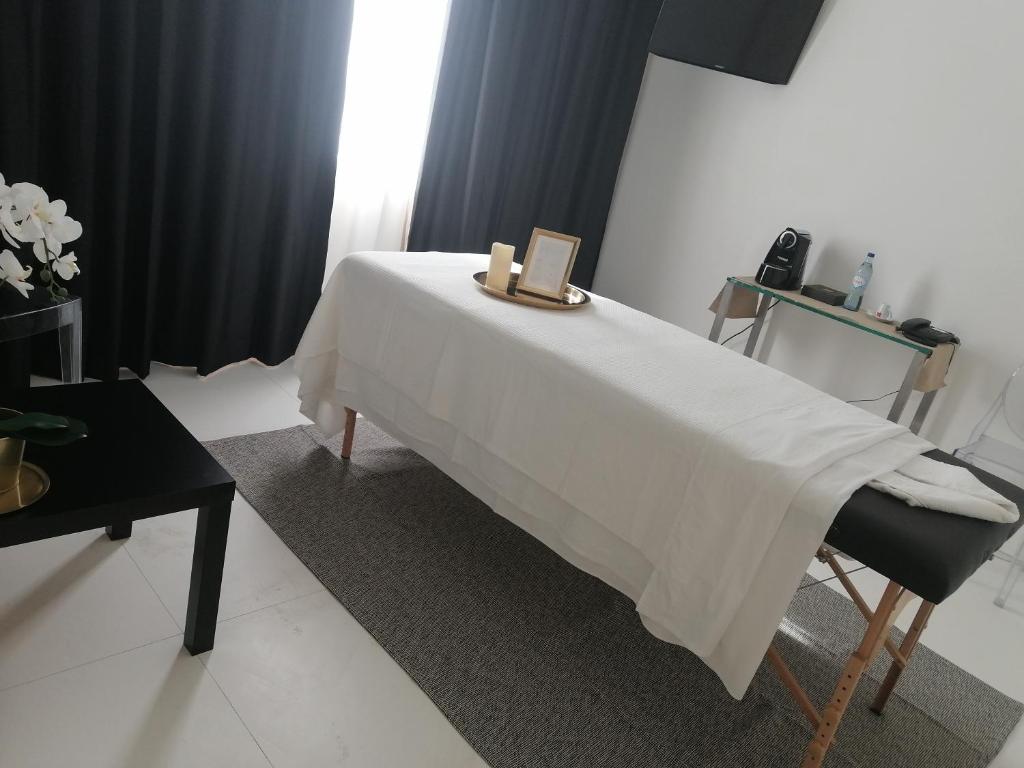 a bed with a white blanket and a box on it at Faro Boutique Hotel in Faro