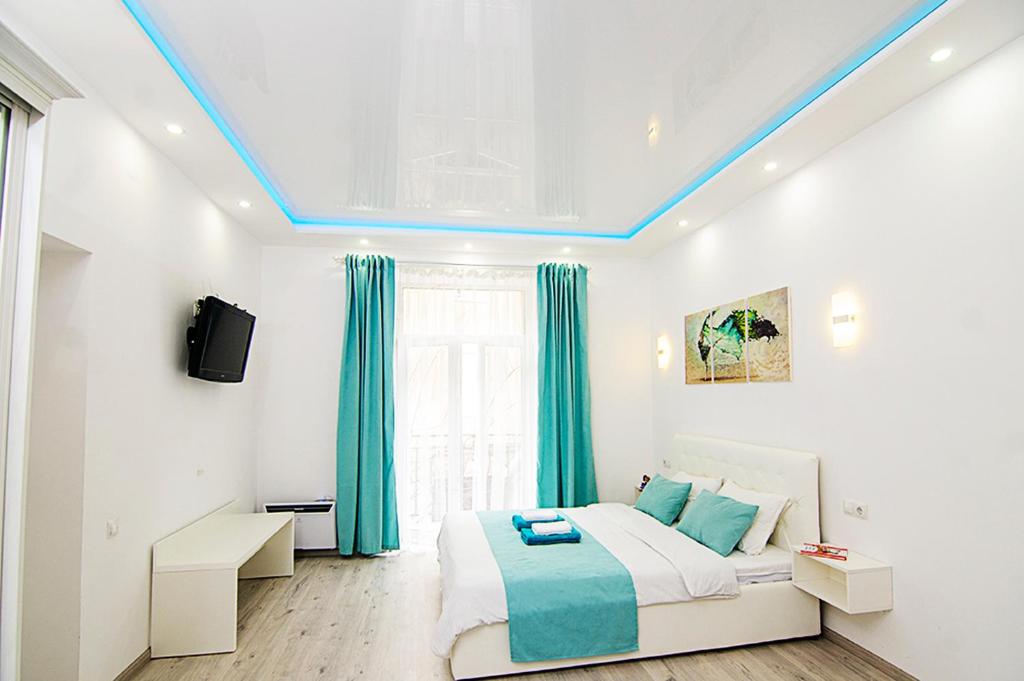 1 dormitorio con 1 cama y techo azul en Austrian Lviv Apartments, en Leópolis