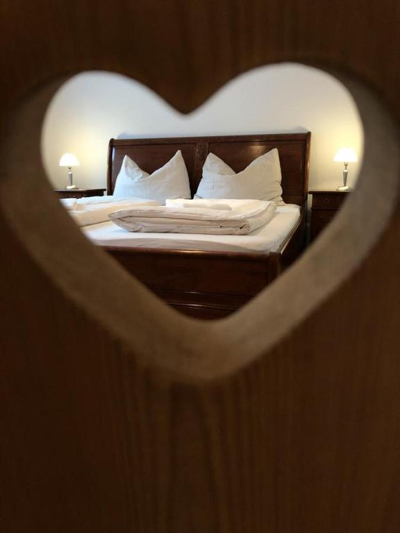 a bedroom with a bed with a heart shaped mirror at CityApartment MELITTA in Schladming