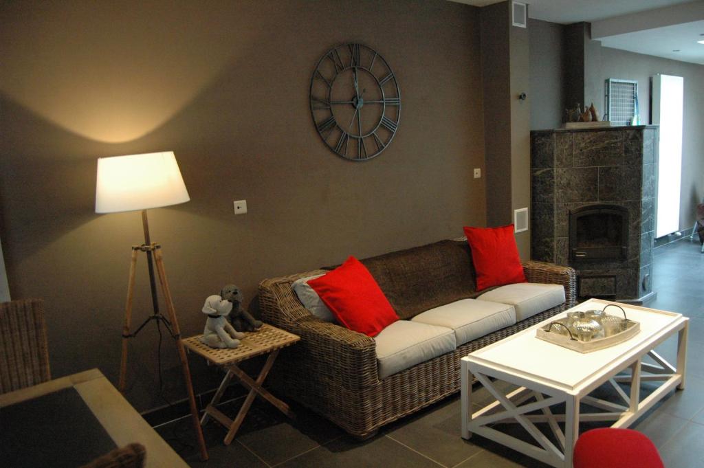 a living room with a couch and a clock on the wall at Holiday Home Family @ home 97 in Bruges