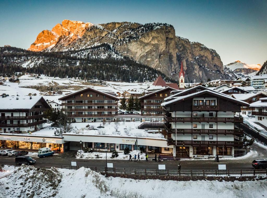 um resort nas montanhas com neve no chão em Residence Antares em Selva di Val Gardena