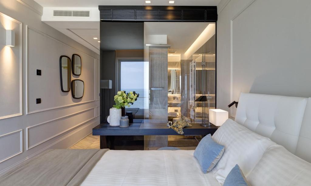 een slaapkamer met een wit bed en een woonkamer bij Hotel Abner's in Riccione