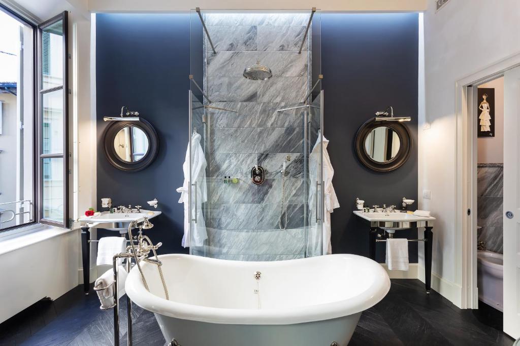 a bathroom with a tub, sink, mirror and bathtub at Corte Calzaiuoli Elegant Suites in Florence