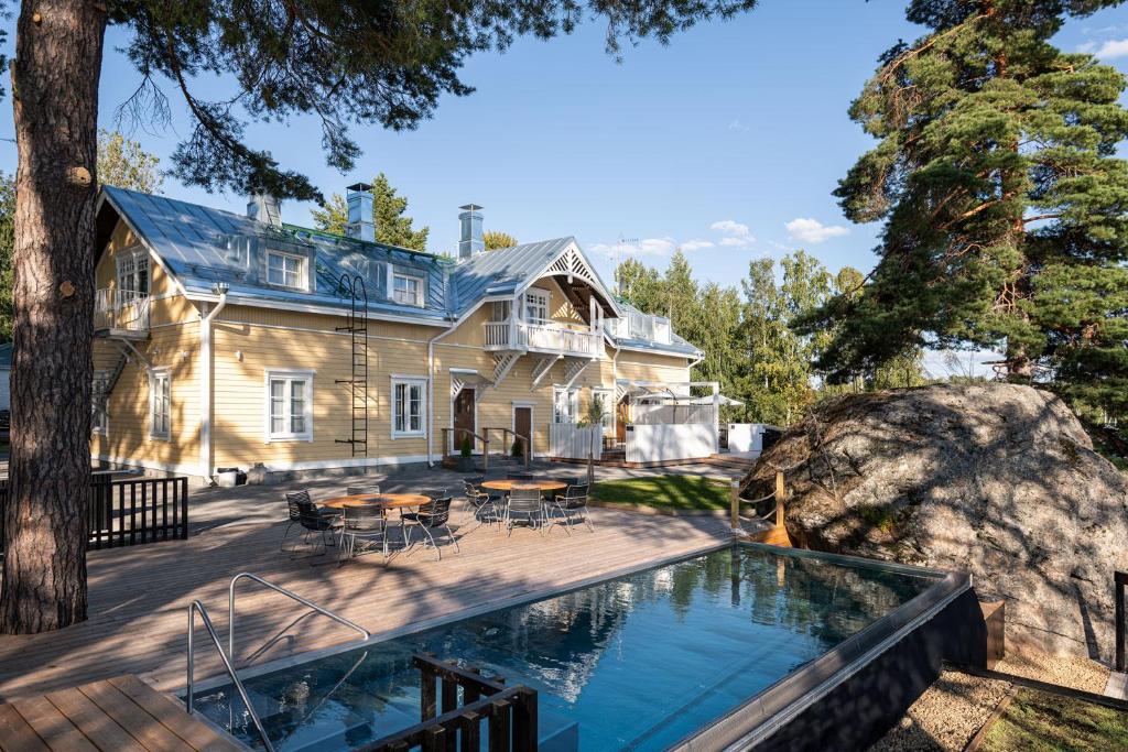 uma casa com piscina em frente a uma casa em Ilola Inn em Sysmä