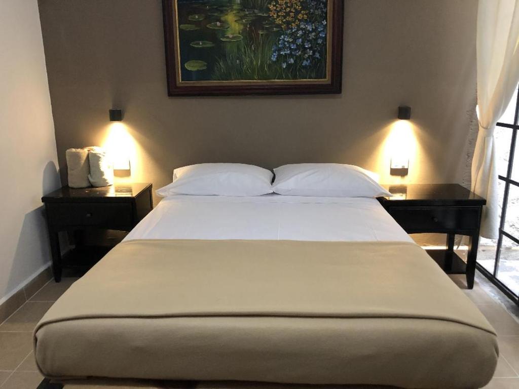 Hostel Inn في سان ميغيل دي الليندي: غرفة نوم بسرير كبير مع مواقف ليلتين