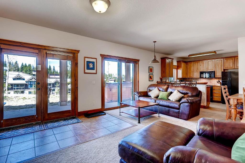 a living room with leather furniture and a kitchen at Saddlewood #46 Ski-In/Ski-Out to Snowflake Lift - Walk to Town in Breckenridge