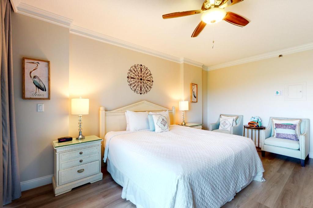 a bedroom with a white bed and a ceiling fan at TOPS'L Summit II in Destin