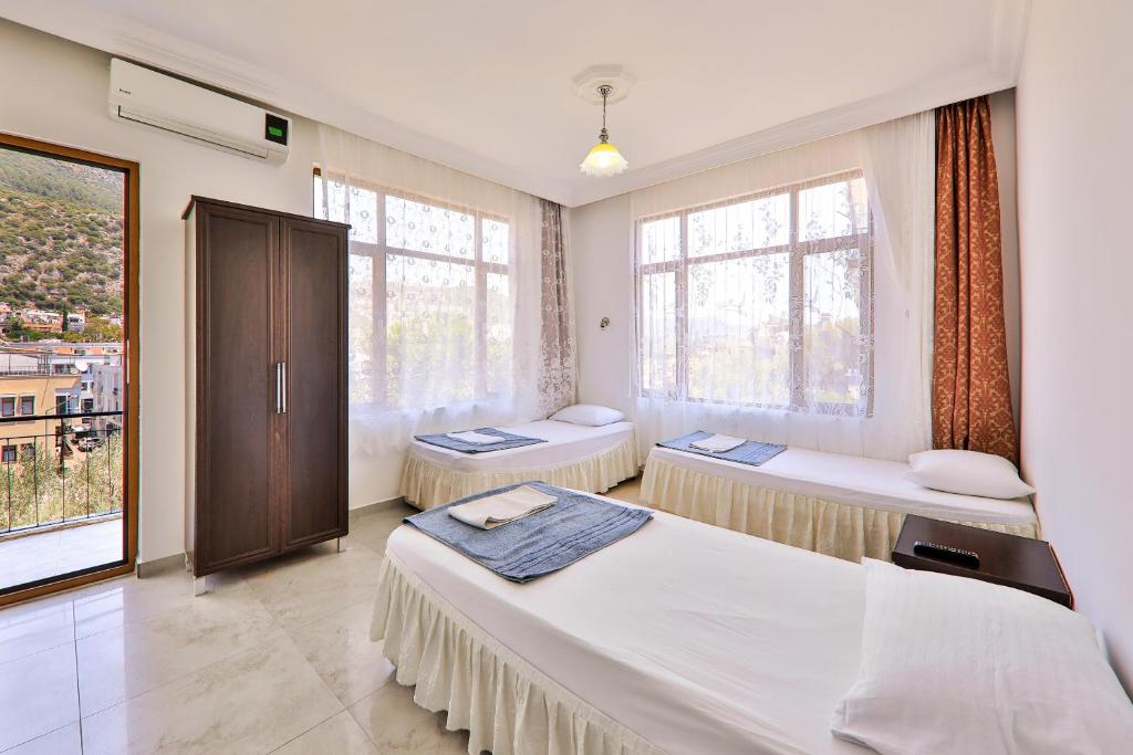a bedroom with two beds and a window at Santosa Pension in Kaş