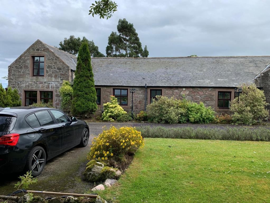 a car parked in front of a stone house at Crawfield Grange in Stonehaven