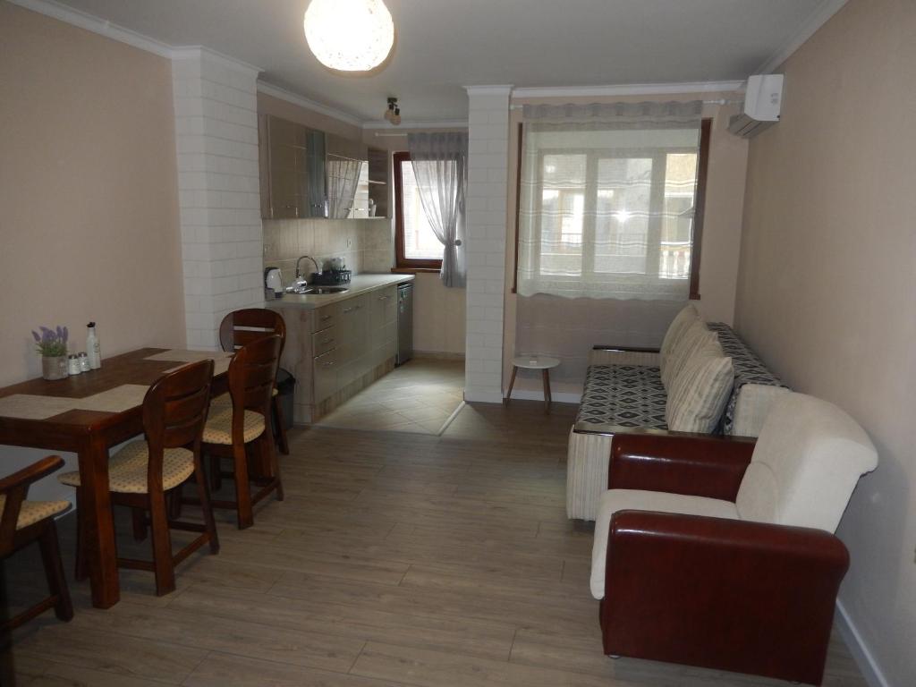 a kitchen and living room with a table and a couch at LERA APARTMENT in Burgas City