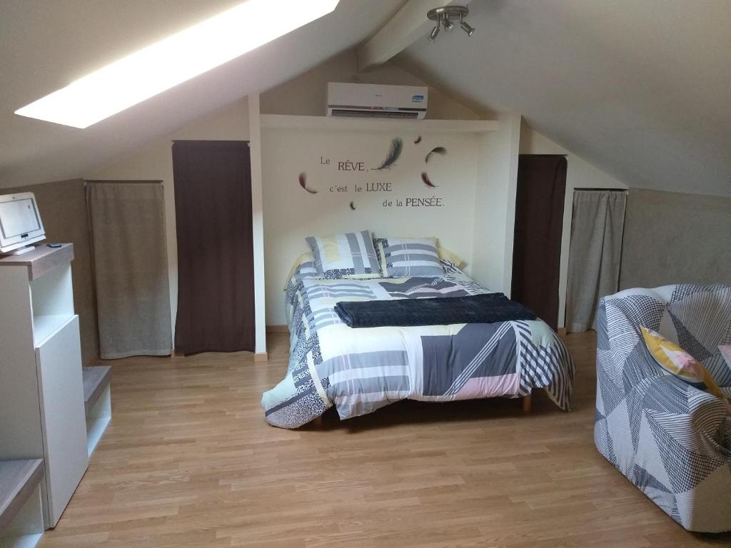 a bedroom with a bed with blue and white sheets at Le Manant in Bellegarde-sur-Valserine