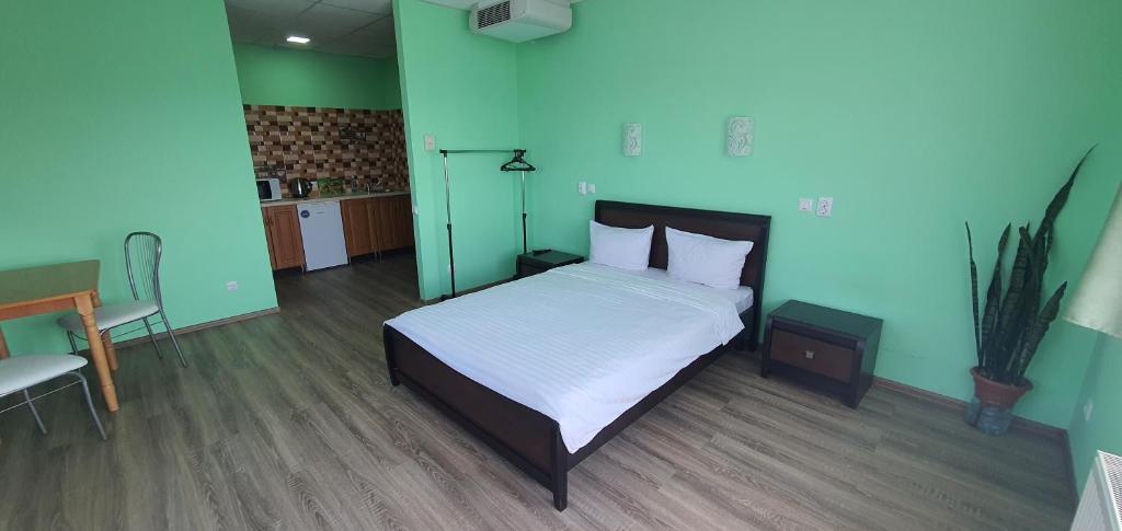 um quarto com uma cama e uma parede azul em Luxor Inn & Suites em Chernivtsi