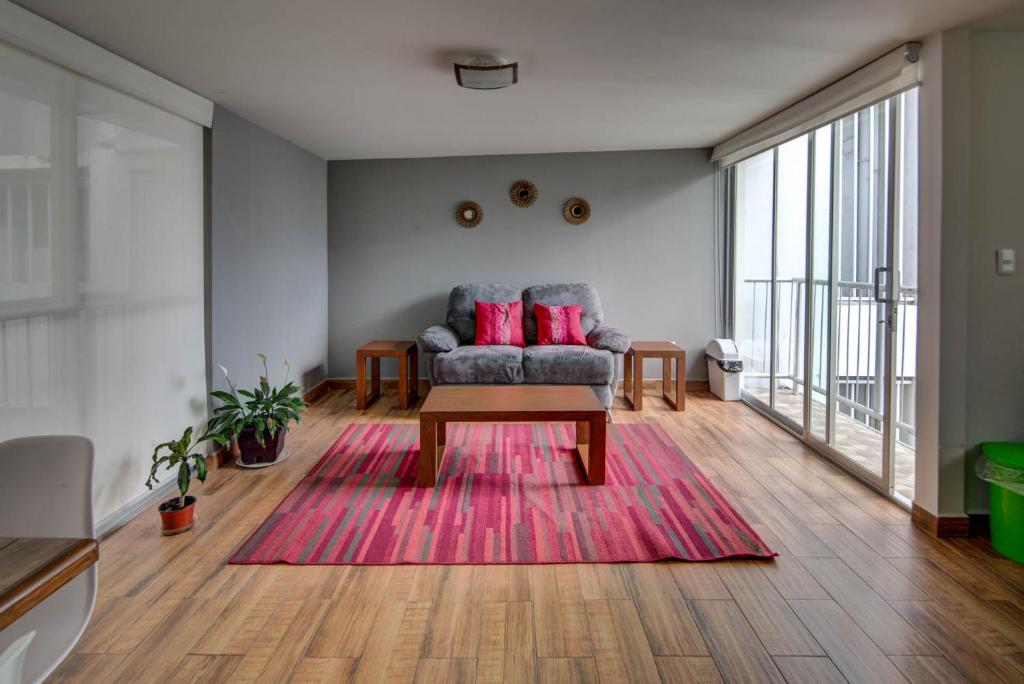 - un salon avec un canapé et un tapis rouge dans l'établissement Grupo Kings Suites - Horacio 1525, à Mexico