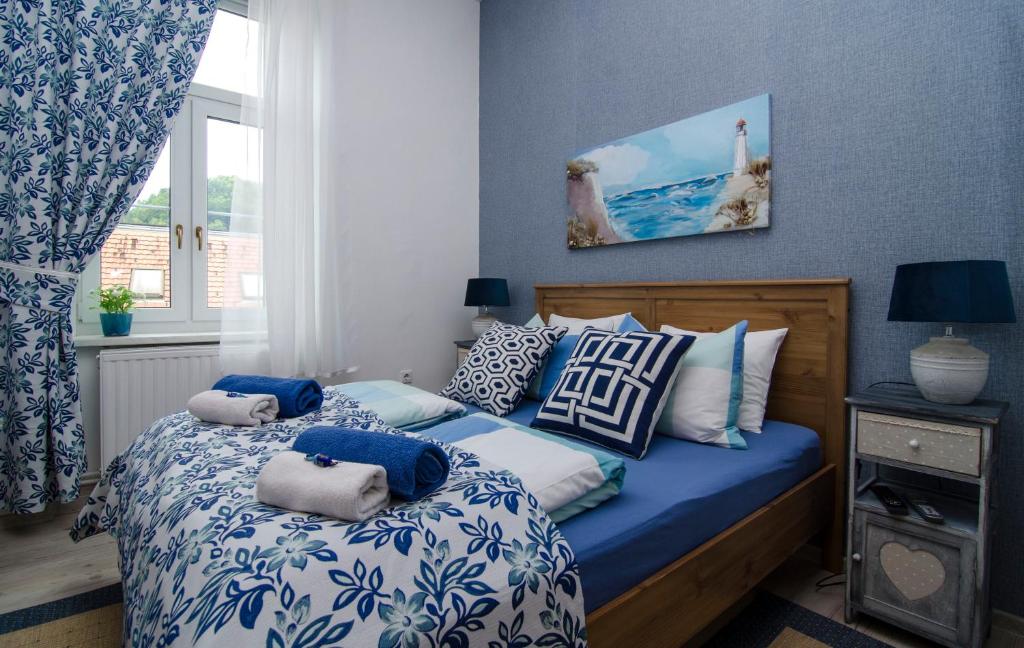 a bedroom with a blue and white bed with pillows at Family Boutique Hotel Trubarjev in Laško