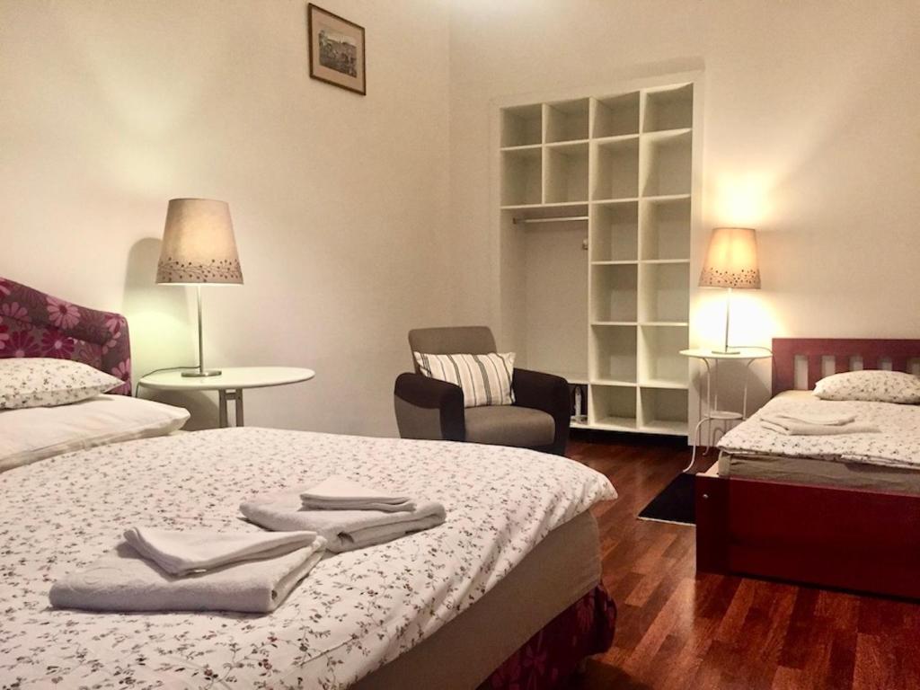 um quarto de hotel com duas camas e uma cadeira em Apartments Emma em Praga