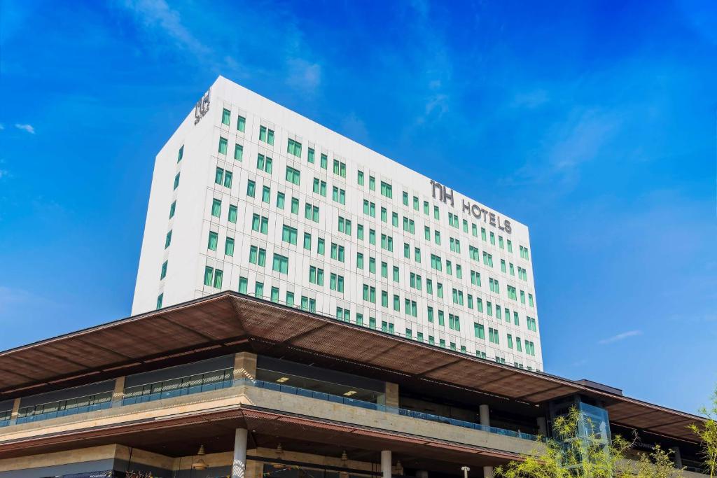 a white hotel building with a blue sky in the background at NH Monterrey La Fe in Monterrey