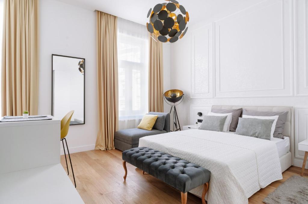 um quarto branco com uma cama e uma cadeira em THE City Lodge - Boutique Apartments em Zagreb