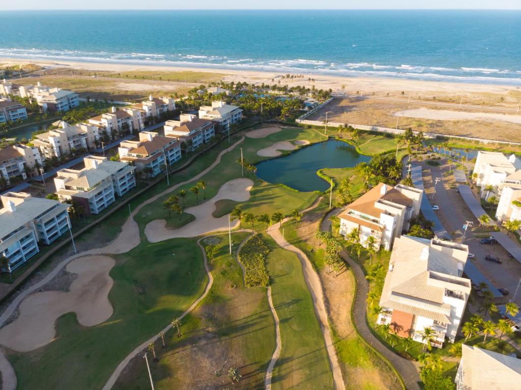 アキラスにあるGolf Ville Resorts Suitesのゴルフコースと海を望むリゾートの空中ビュー