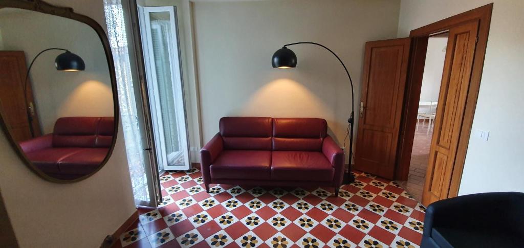 - un canapé en cuir rouge dans une pièce avec un miroir dans l'établissement Dalla Raffy, à La Spezia