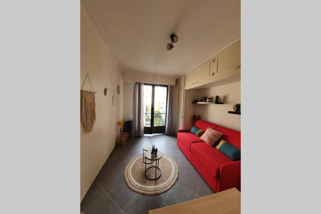 un salon avec un canapé rouge et une table dans l'établissement Studio cosy et calme, au cœur de Nice Libération, à Nice