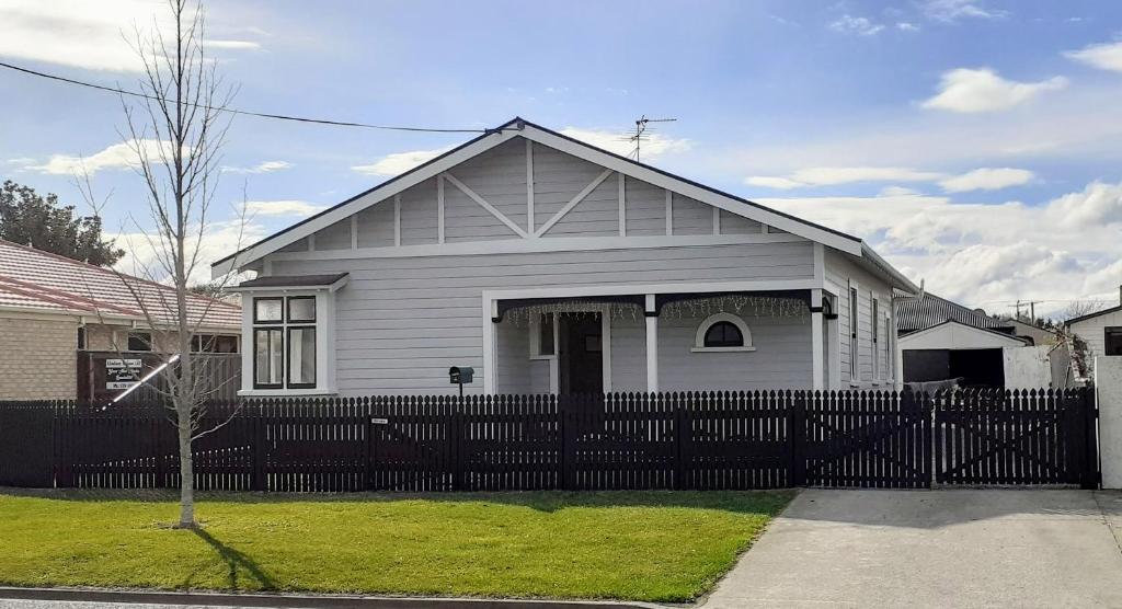 una casa blanca con una valla delante en Te Waiharakeke Holiday Home, en Blenheim