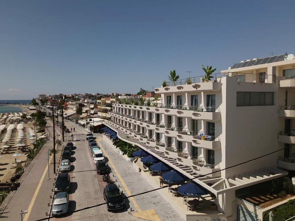 Vista árida de un edificio en una calle con coches aparcados en Aegean Blue Beach Hotel, en Nea Kalikratia